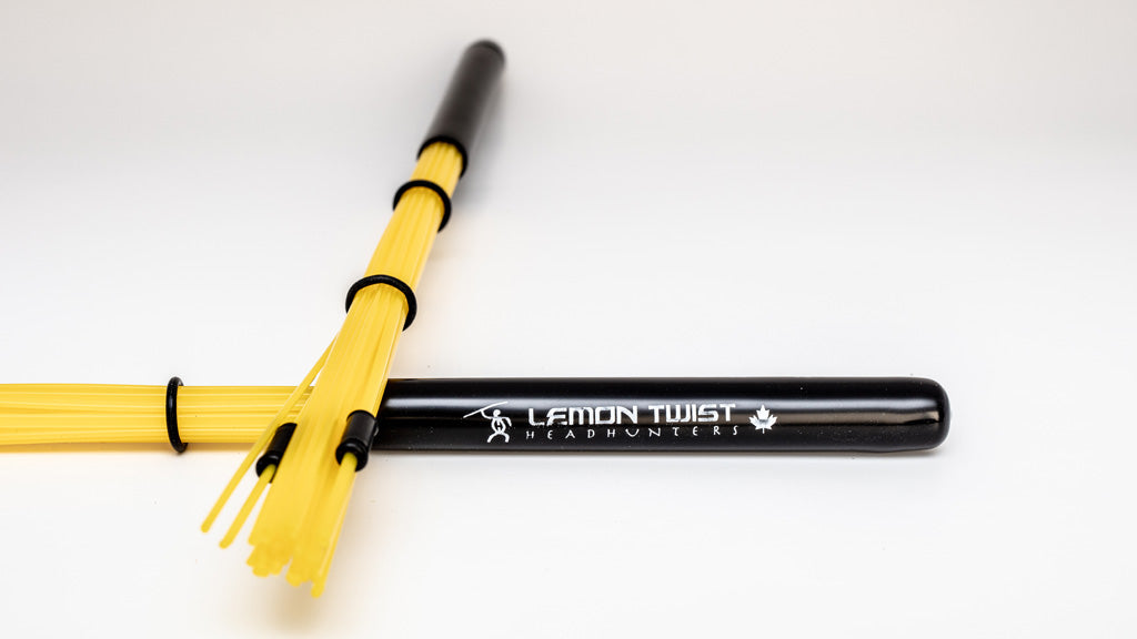HeadHunters Lemon Twist — yellow poly hybrid bundle sticks with 3 adjustable nylon sleeves for cymbal/drum EQ balance. Made in Canada.
